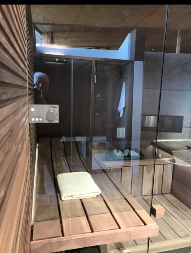 Private Sauna mit Glasfront und Holzverkleidung im Wellnessbad